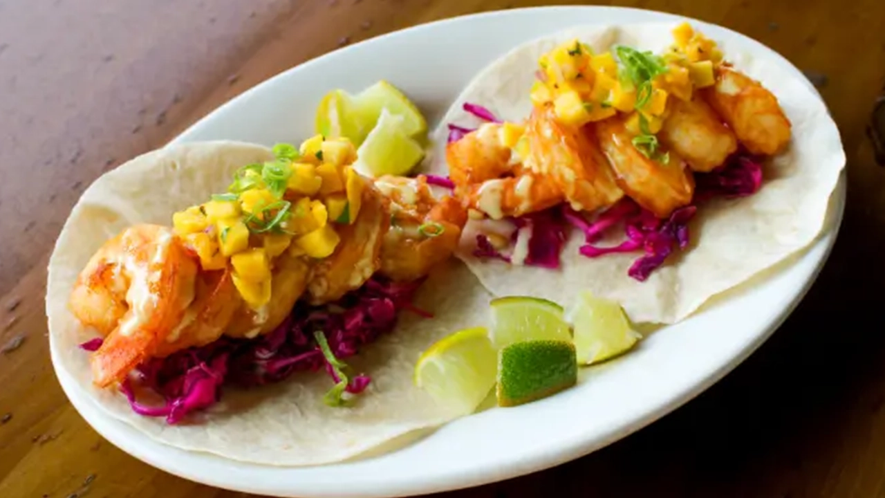 Shrimp tacos own purple coleslaw and topped with mango salsa.