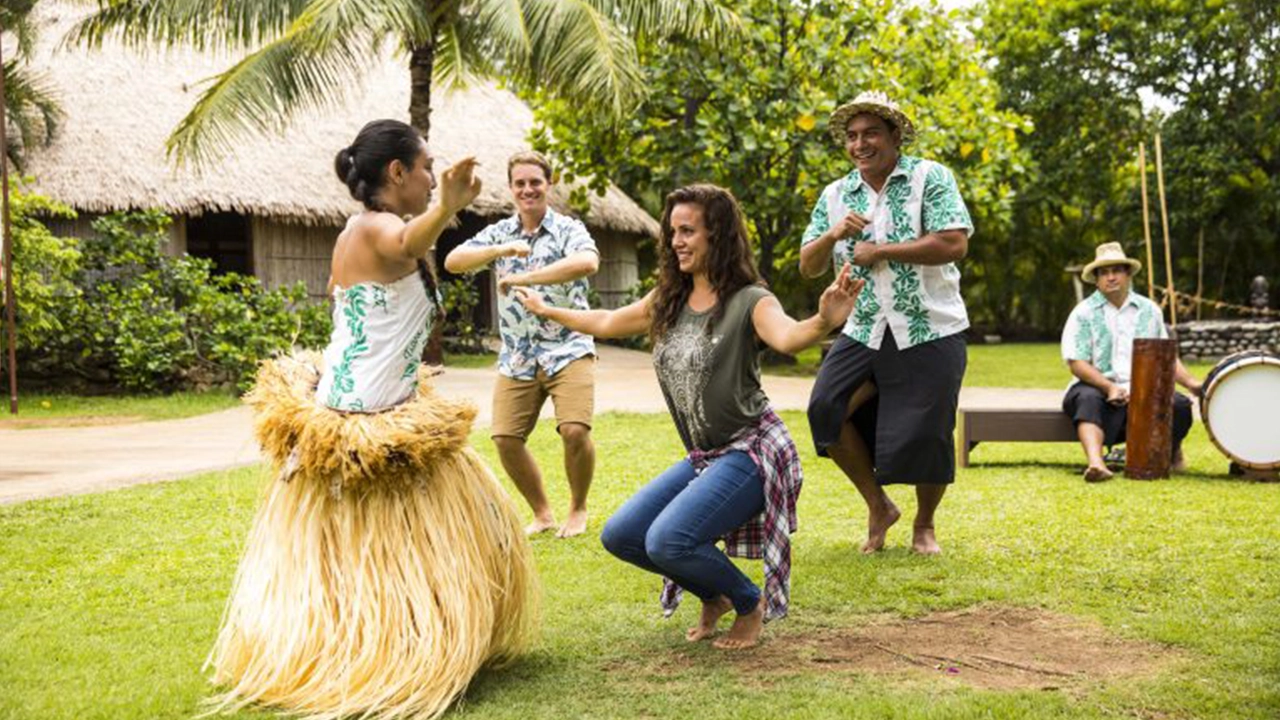 A guest learning about Tahitian ʻōteʻa from a performer at the Polynesian Cultural Center.