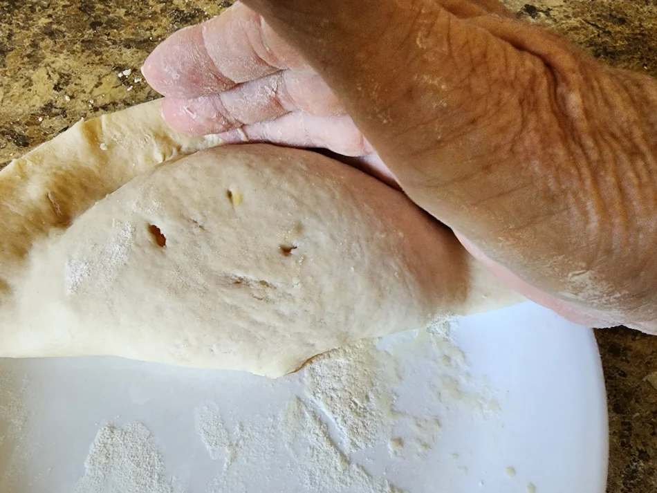 Crust folded in half over the filling to form the paifala.