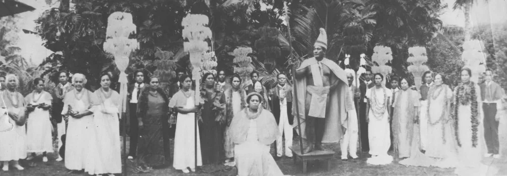 Black and white photograph of Hamana Kalili and locals from Lāʻie portraying the royal court of King Kamehameha, with Kalili serving as the king.