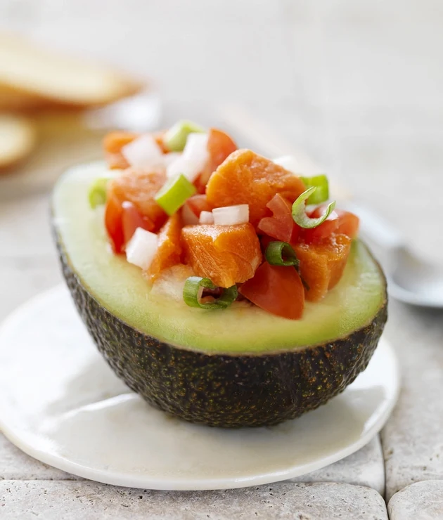 Lomi Lomi Salmon served upon a halved avocado.