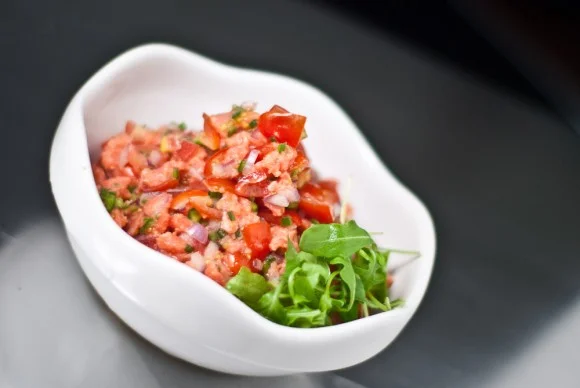 Lomi salmon made with chili pepper in a white bowl.