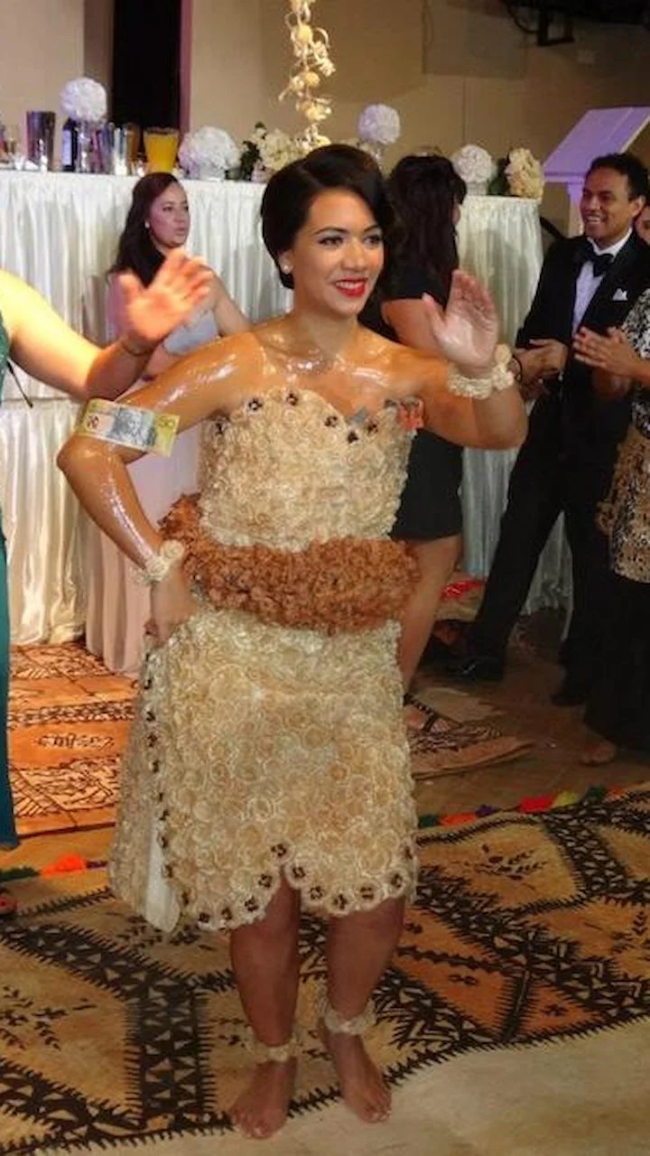 Dancer with prize money presented sticks to the oily body. Wearing traditional attire, dancing in an event.