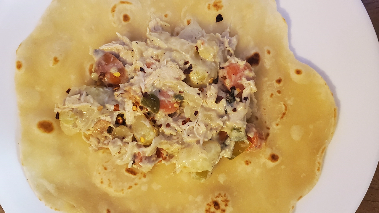 Chicken curry on a roti, ready to roll.