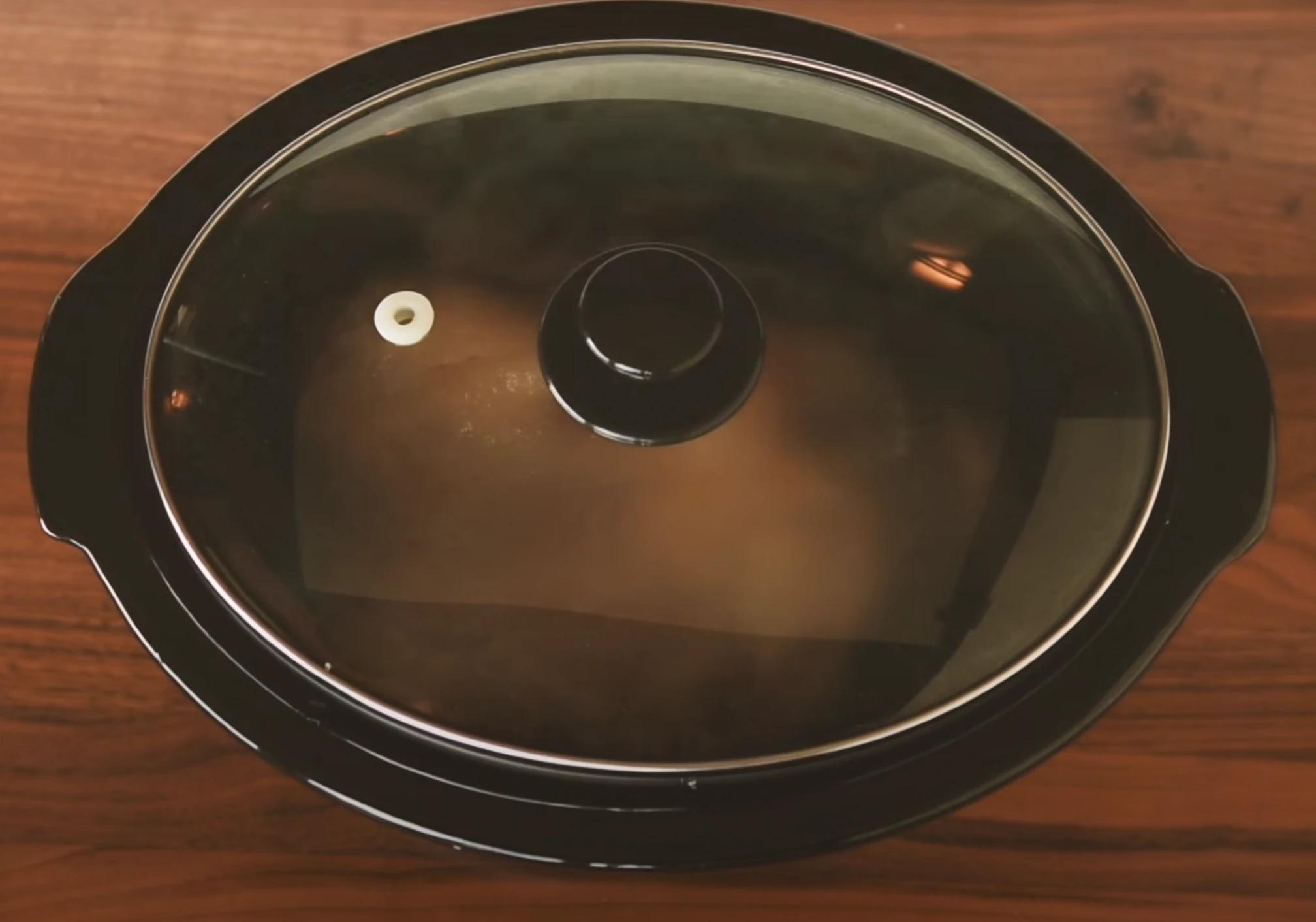 Pork butt cooking in a slow cooker.