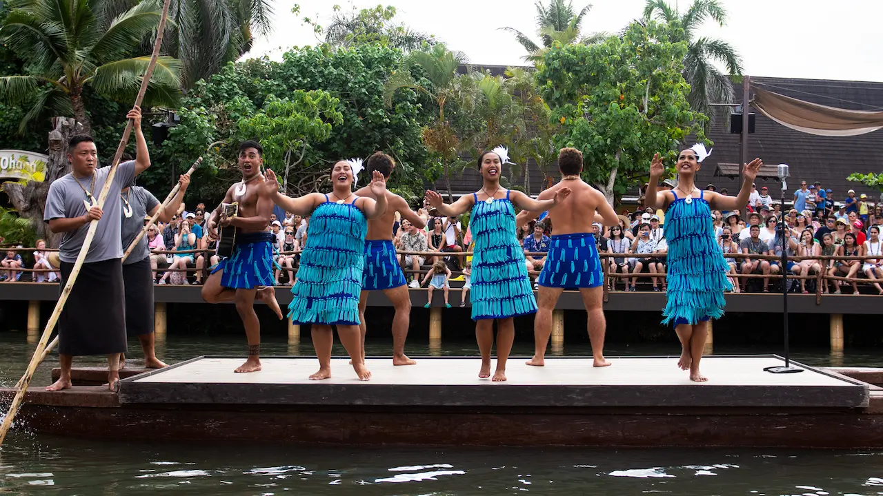 Māori performers in intricate, blue costumes.
