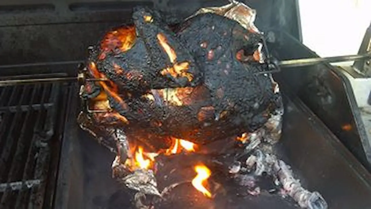 Charred turkey roasted over a grill.