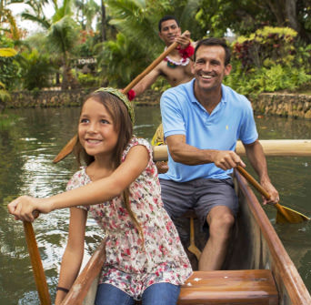 Family paddling a canoe together at the Polynesian Cultural Center.